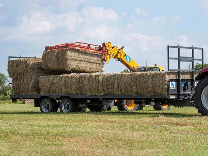 Richard Western 32ft Flatbed trailer being loaded with hay by a SW Hire JCB 542-70 telehandler