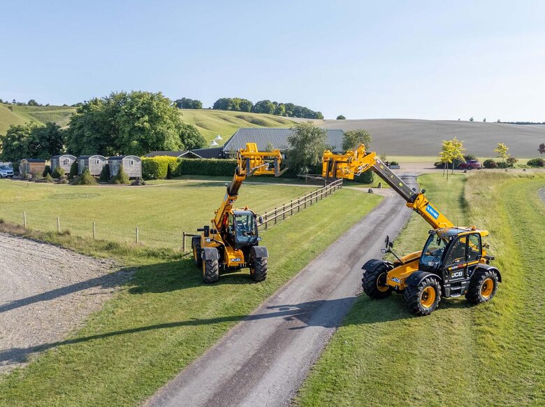 JCB 542-70 and 542-100 agrixtra telehandlers with blue sw hire stickers forming an archway in front of wellington barn
