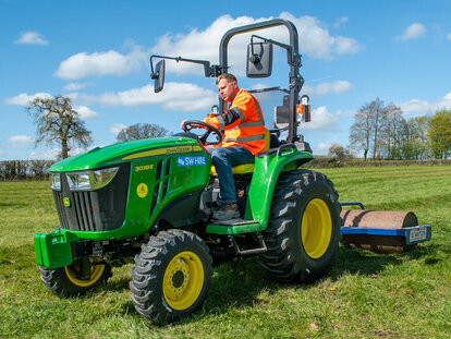 John Deere 3038E compact tractor and roller attachment