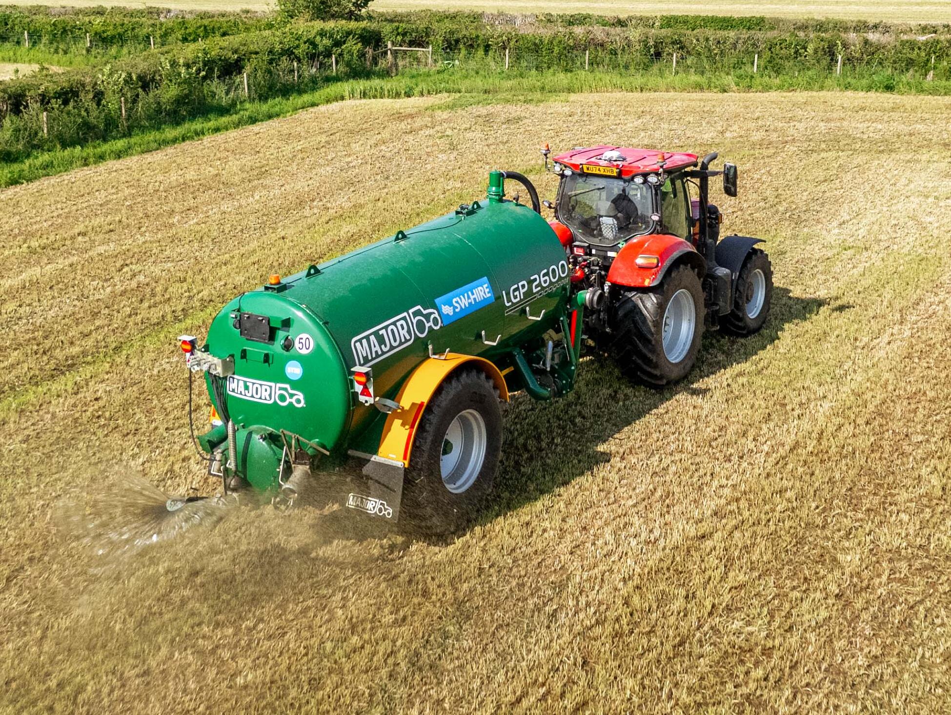 SW-Hire's Major LGP2600 tanker spreading slurry with a splash plate towed by a case tractor on a cut grass field