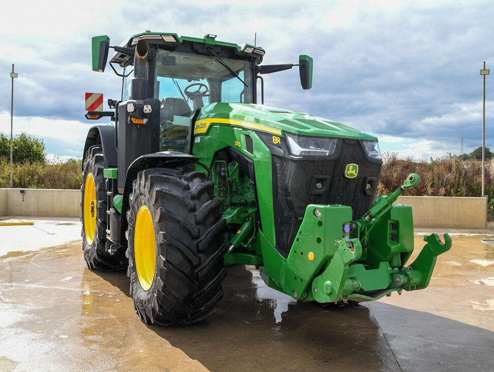 John Deere 8R370 tractor parked on a concrete pad