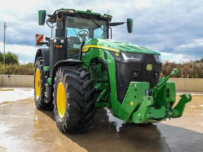 John Deere 8R370 tractor parked on a concrete pad