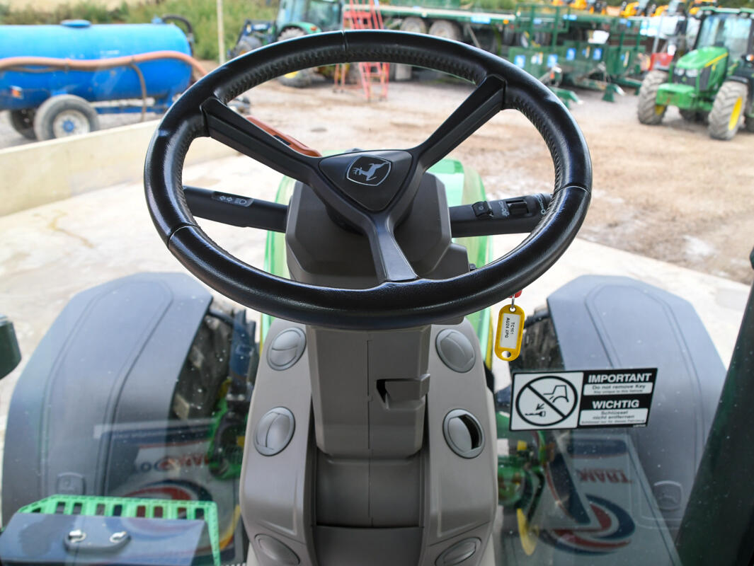 John Deere 8R370 tractor parked on a concrete pad