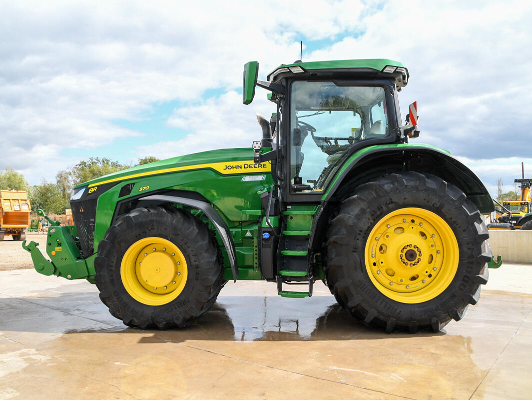 John Deere 8R370 tractor parked on a concrete pad